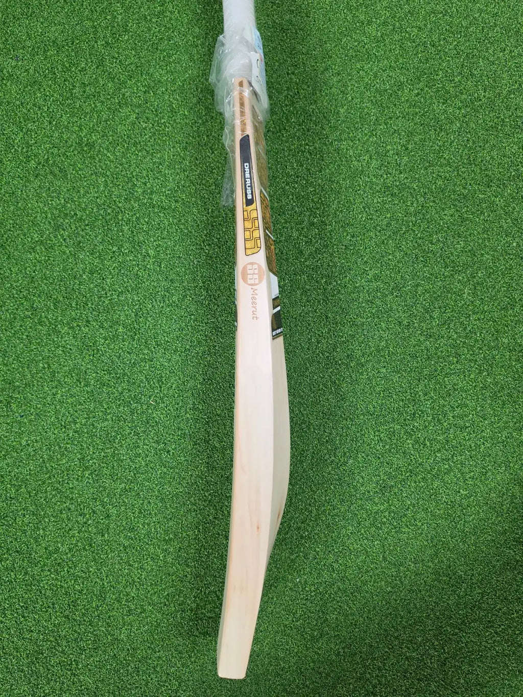 Side edge profile view of SS Ton Gama Player D.Russel English Willow Cricket Bat on green turf at Alberta Cricket Store