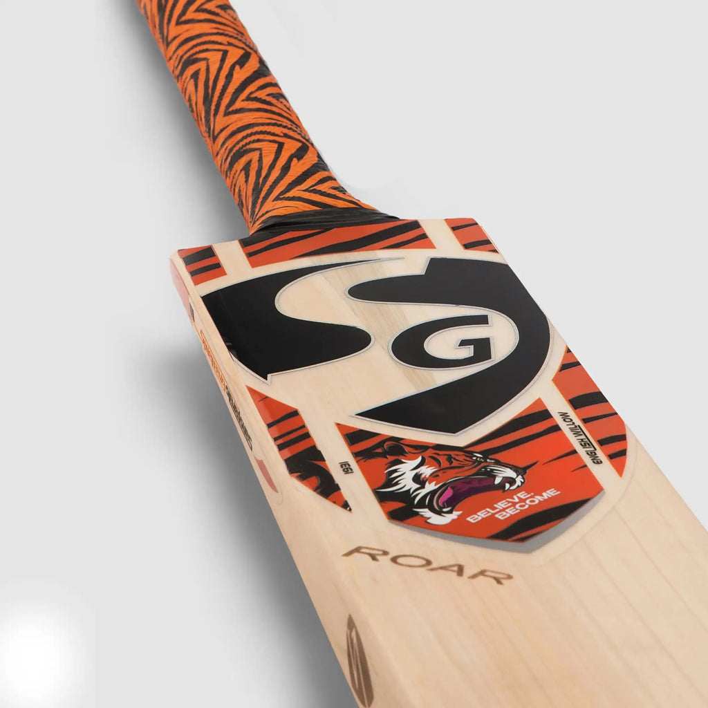 Close-up of SG Roar English Willow cricket bat decal showing tiger logo and textured orange grip.