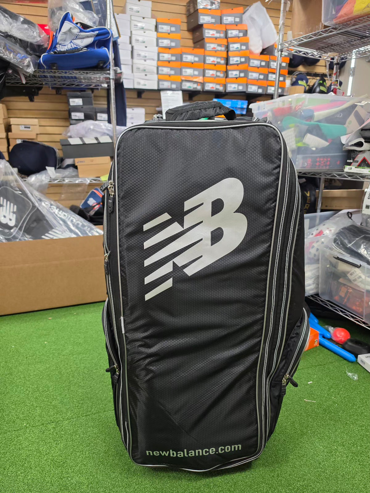 Front view of a premium black New Balance 10i combo duffle wheelie cricket kit bag featuring the large white NB logo.