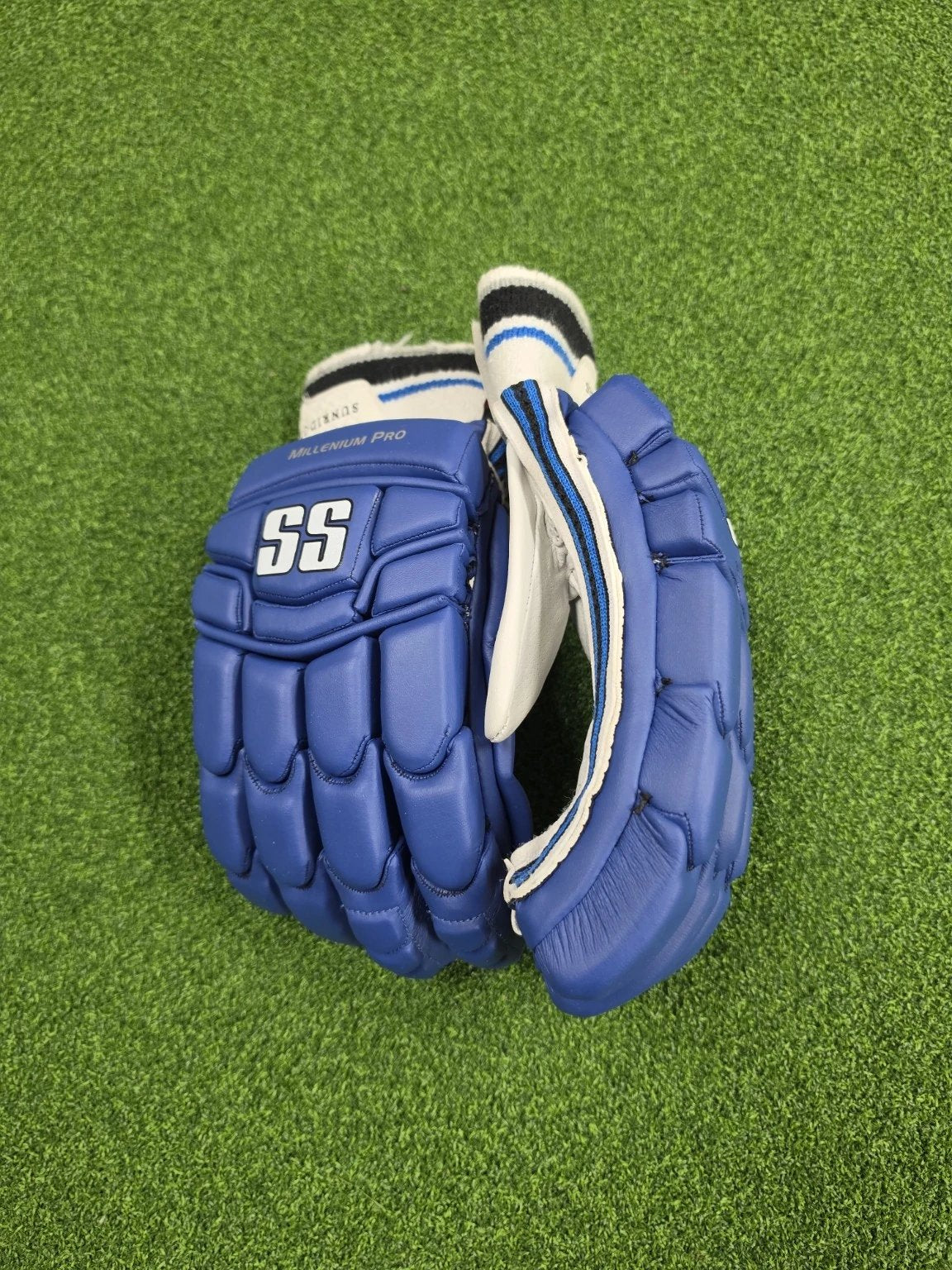 Angled backhand view of blue and white SS TON Millennium Pro adult cricket batting gloves showing SS branding and finger casing