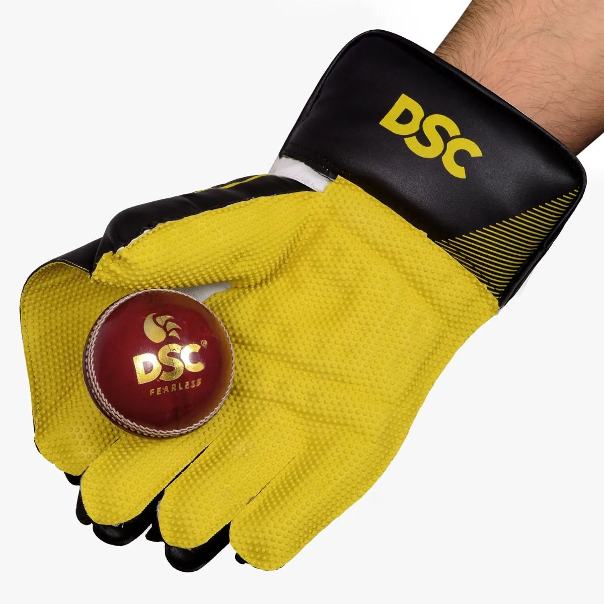 DSC Condor Ruffle Wicket Keeping Glove holding a red DSC cricket ball at Alberta Cricket Store