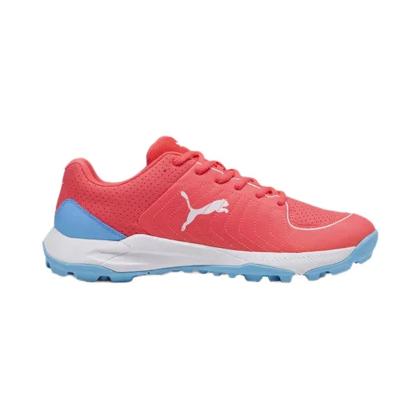 Side profile view of a red Puma 24 FH Rubber Cricket Shoe featuring a white Puma cat logo, light blue heel accent, white midsole, and light blue rubber studded outsole.